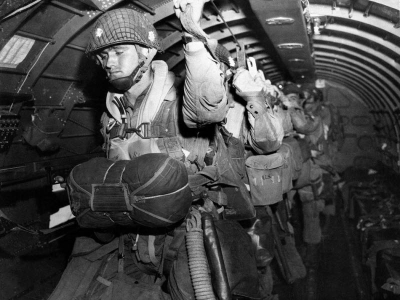 US paratroopers fix static lines before jumping over Normandy