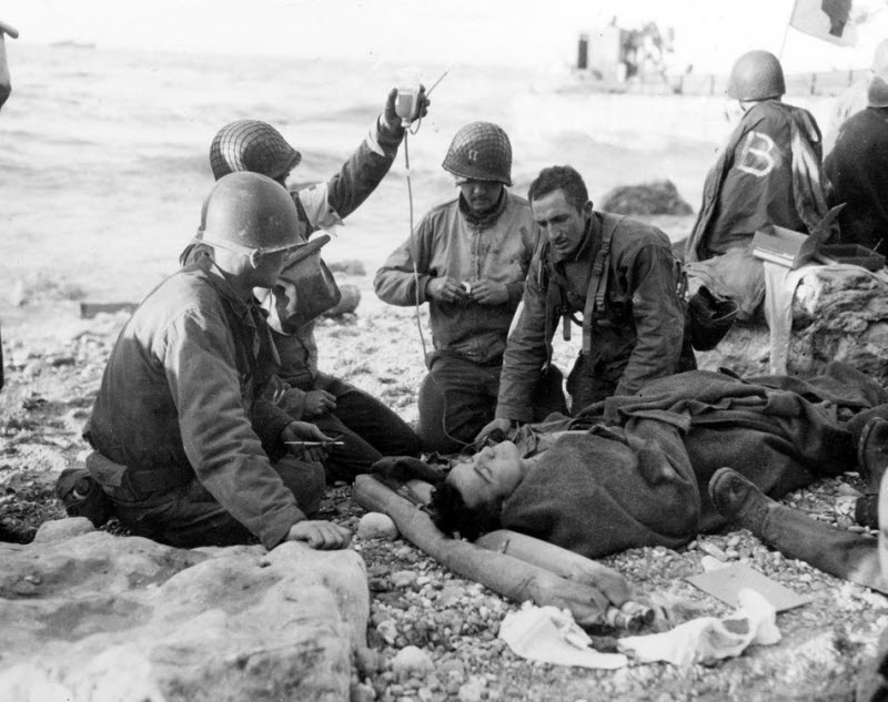 US Army medical personnel administer plasma transfusion at Normandy