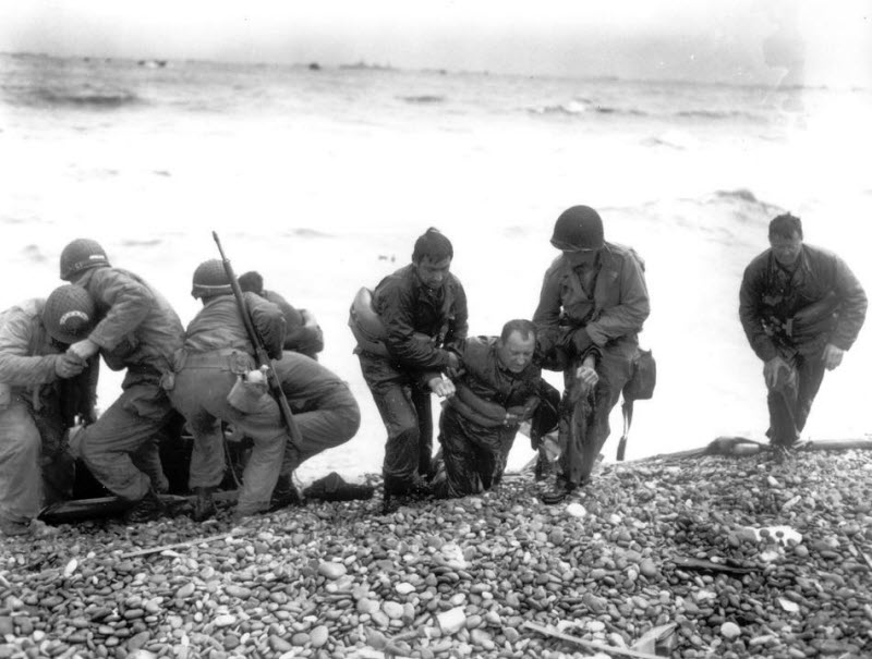 American landing unit helps exhausted comrades ashore at Utah Beach
