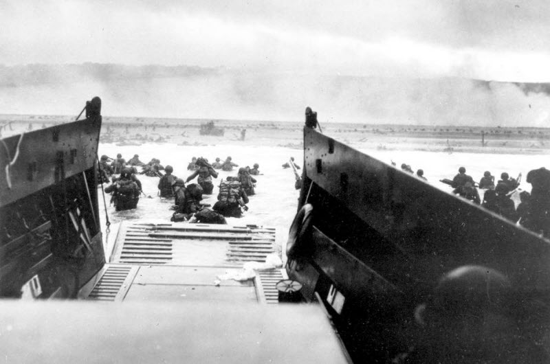 American infantrymen wade ashore under heavy German fire at Normandy