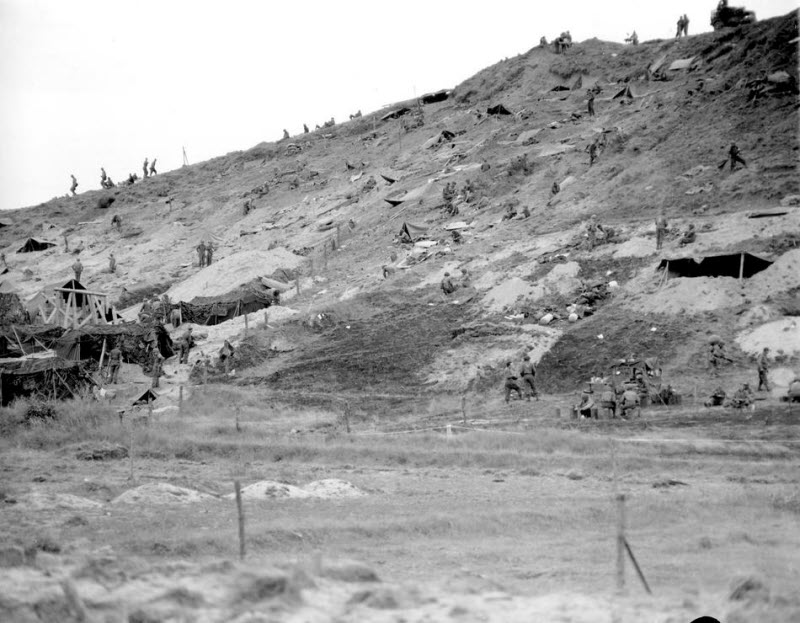 Allied forces camp on hillside overlooking Normandy beach